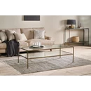 Rectangular glass coffee table with brass legs and a glass shelf styled in a living room with Scandi influences
