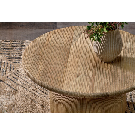 Round mango wood coffee table with grooved texture in a living room 2
