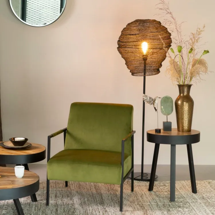 Mesh floor lamp illuminating a green chair and side table