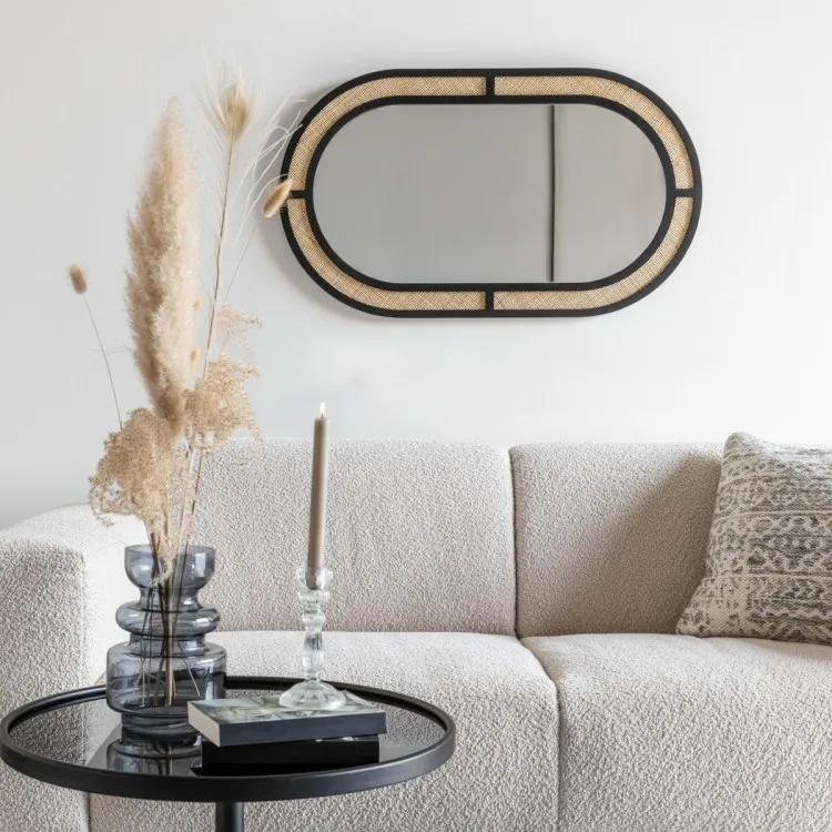 Oval mirror above a white sofa and circular coffee table