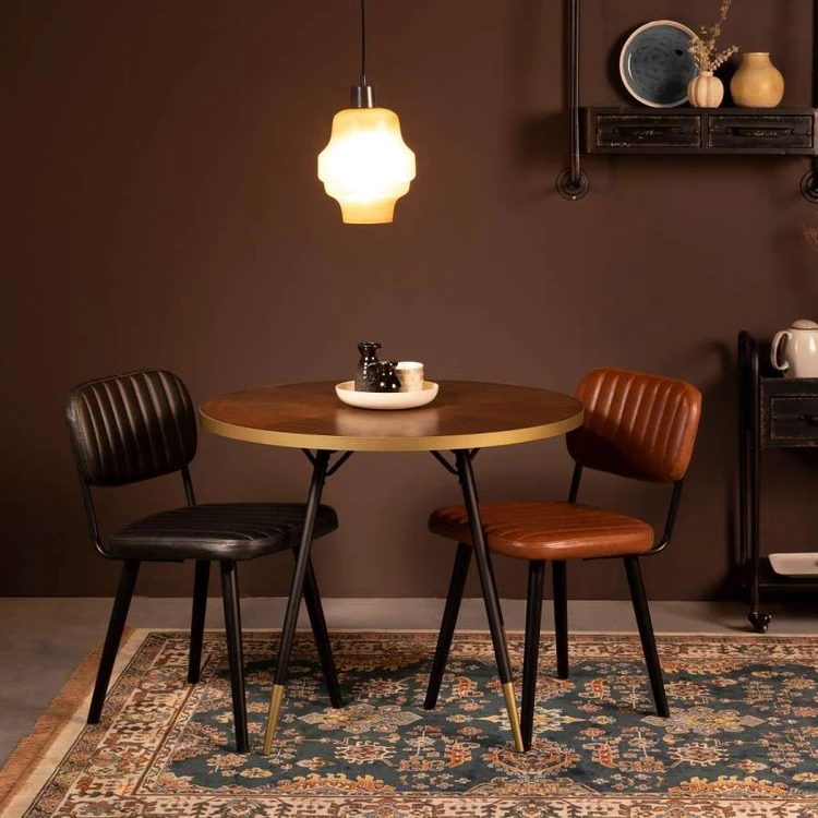 Black and brown leather chairs around a round dining table in a retro style room