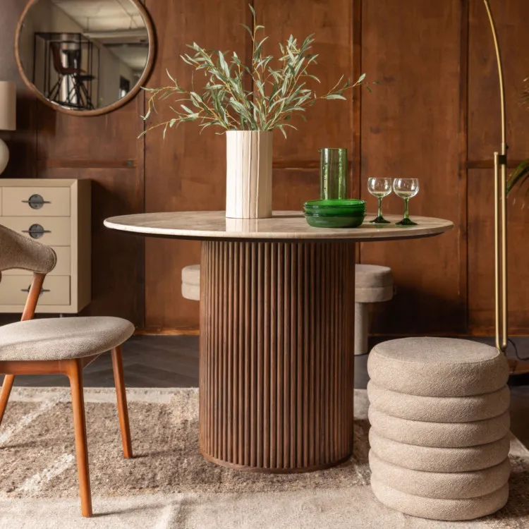Dutchbone dining table surrounded by chairs in a room with a wood panelled wall