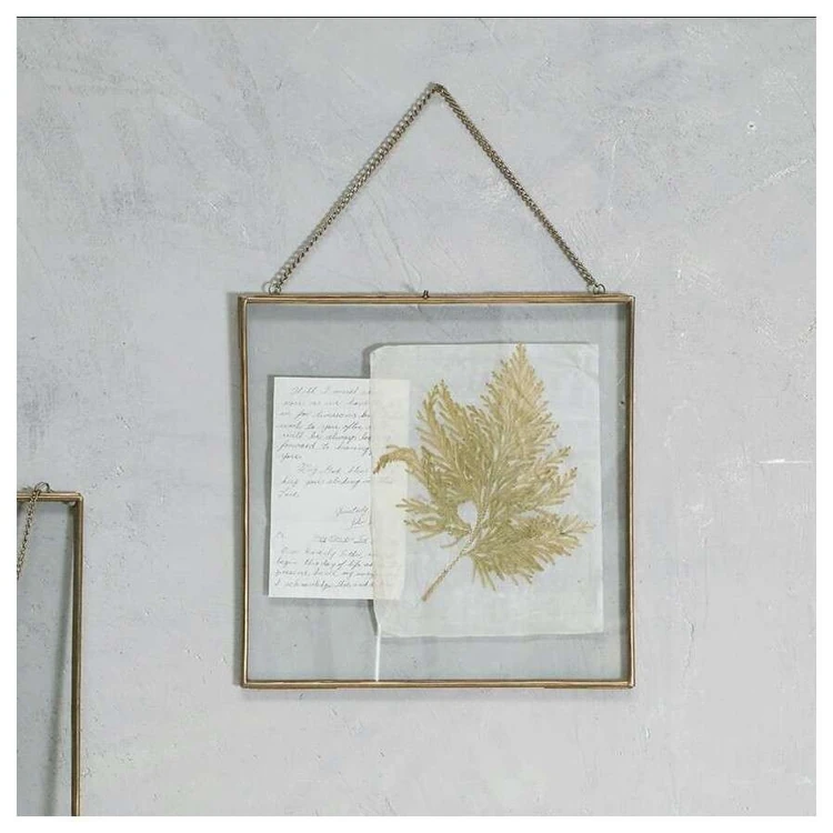 A pressed leaf and letter in a glass photo frame