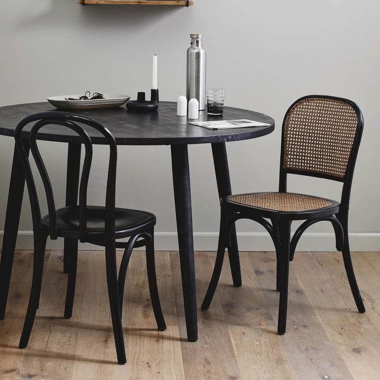 Black chairs in different styles around a circular black table