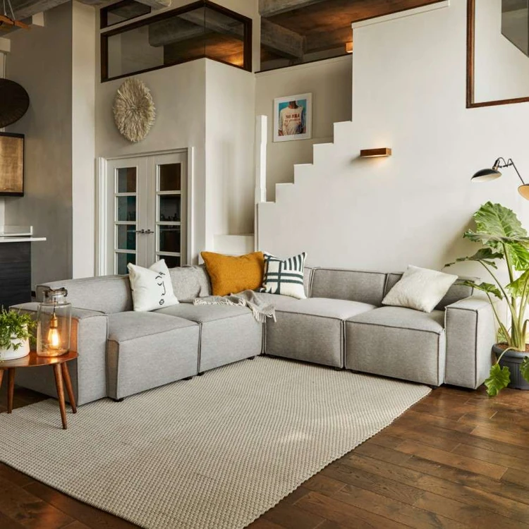 A cosy living room with grey sofa, cushions and rug